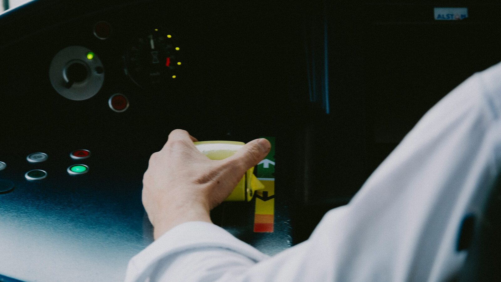 Operator pressing a button on an industrial control panel