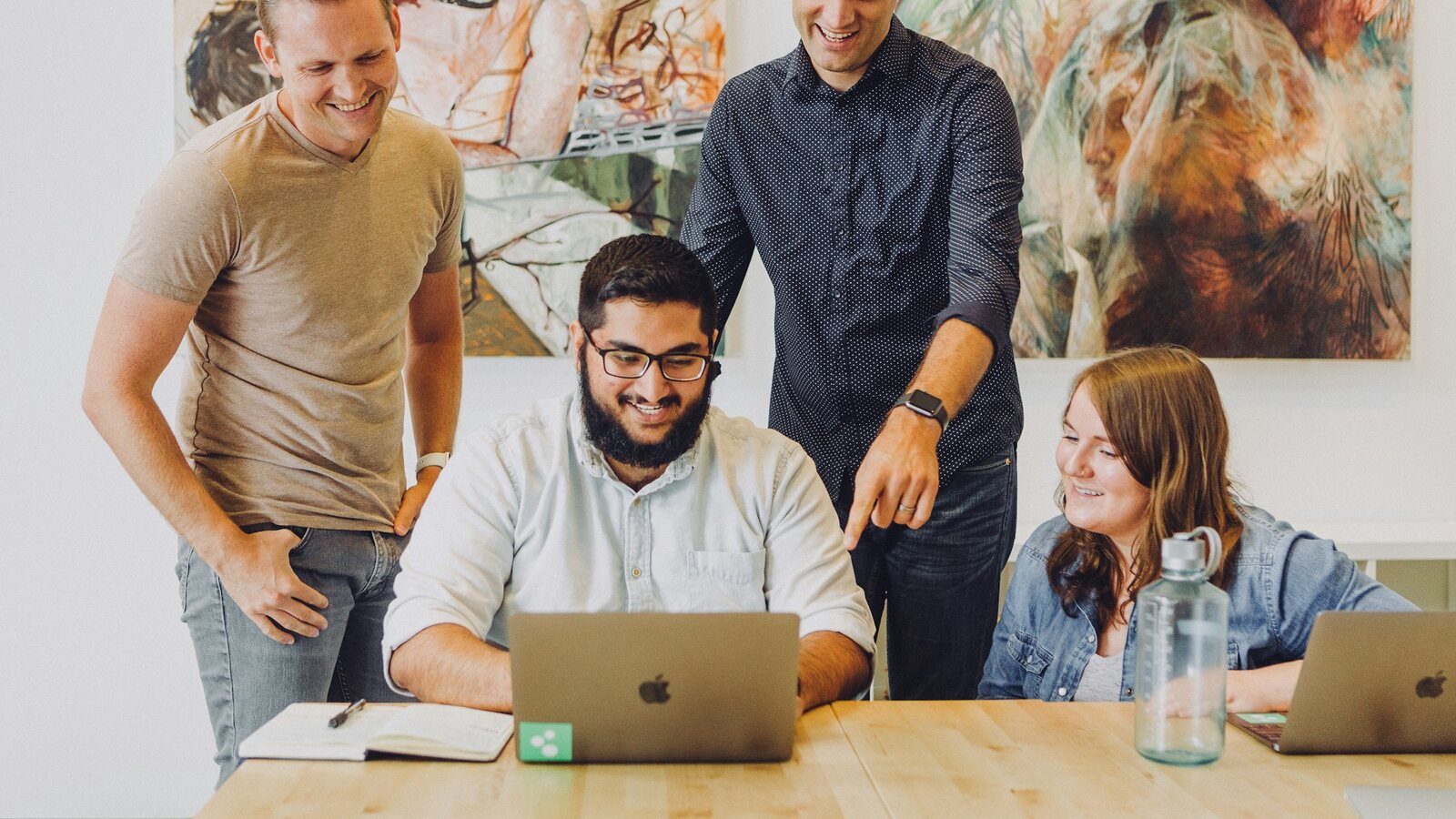 Small team discussing options around a laptop