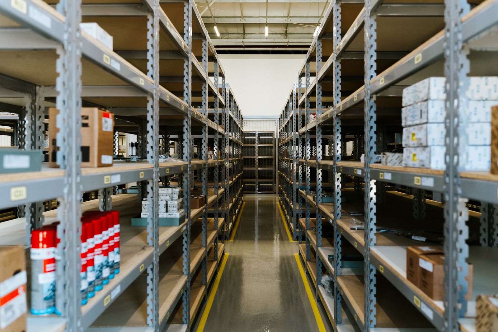 Industrial warehouse with rows of metal shelving holding stored merchandise