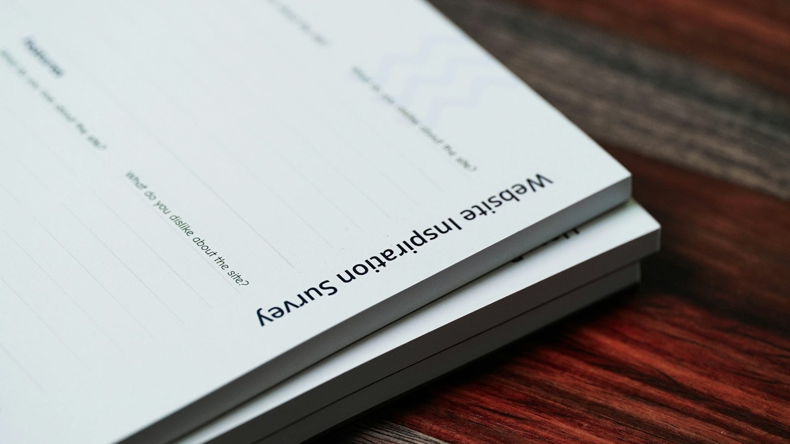 A stack of paper documents sitting on a wooden table