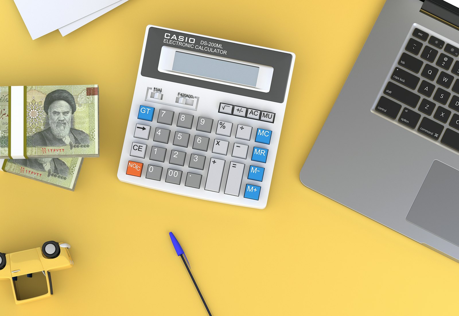 Calculator on a desk next to a laptop