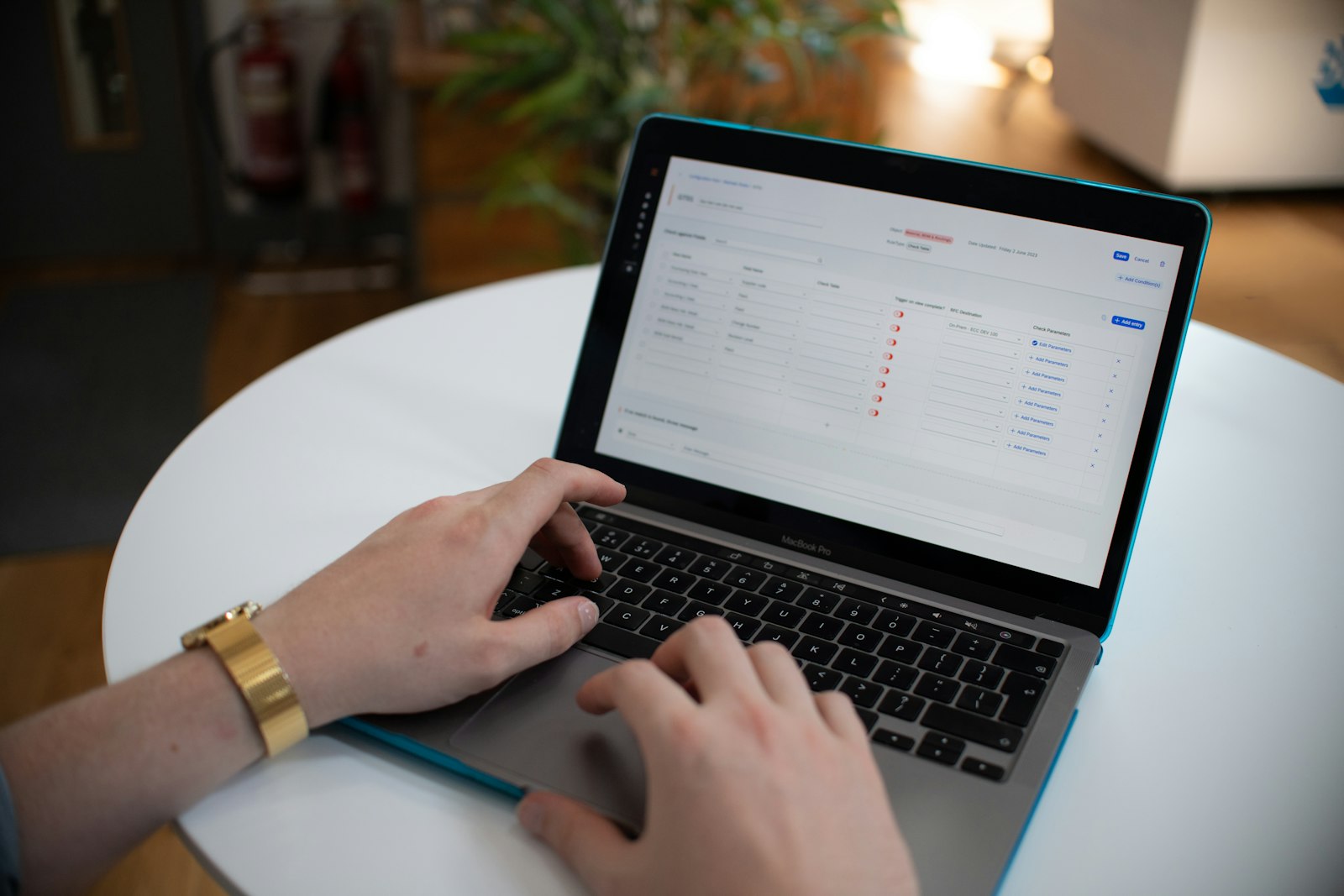 Hands typing on a laptop keyboard with a spreadsheet open on the screen