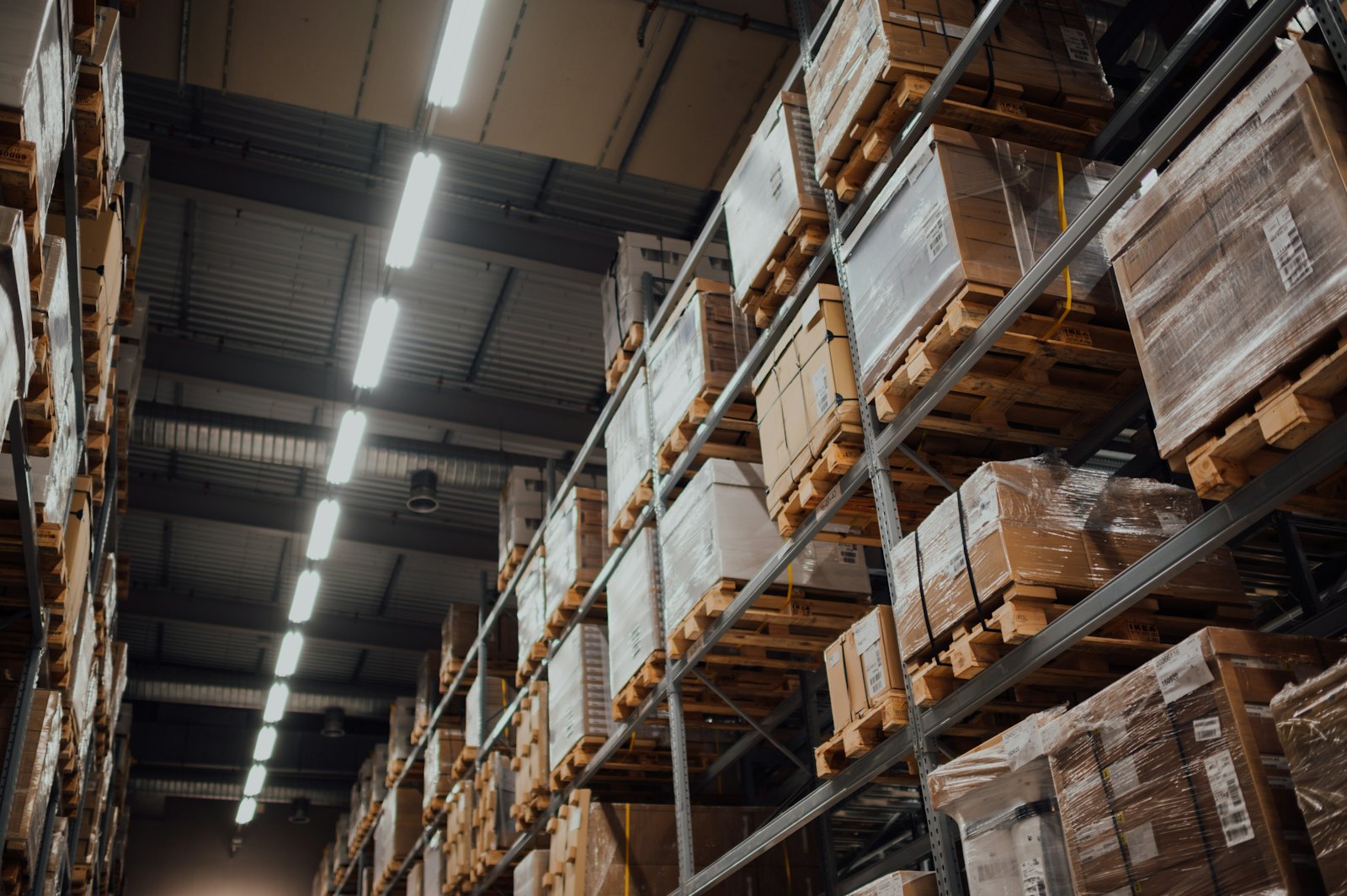 Brown cardboard boxes stored on white metal warehouse racking