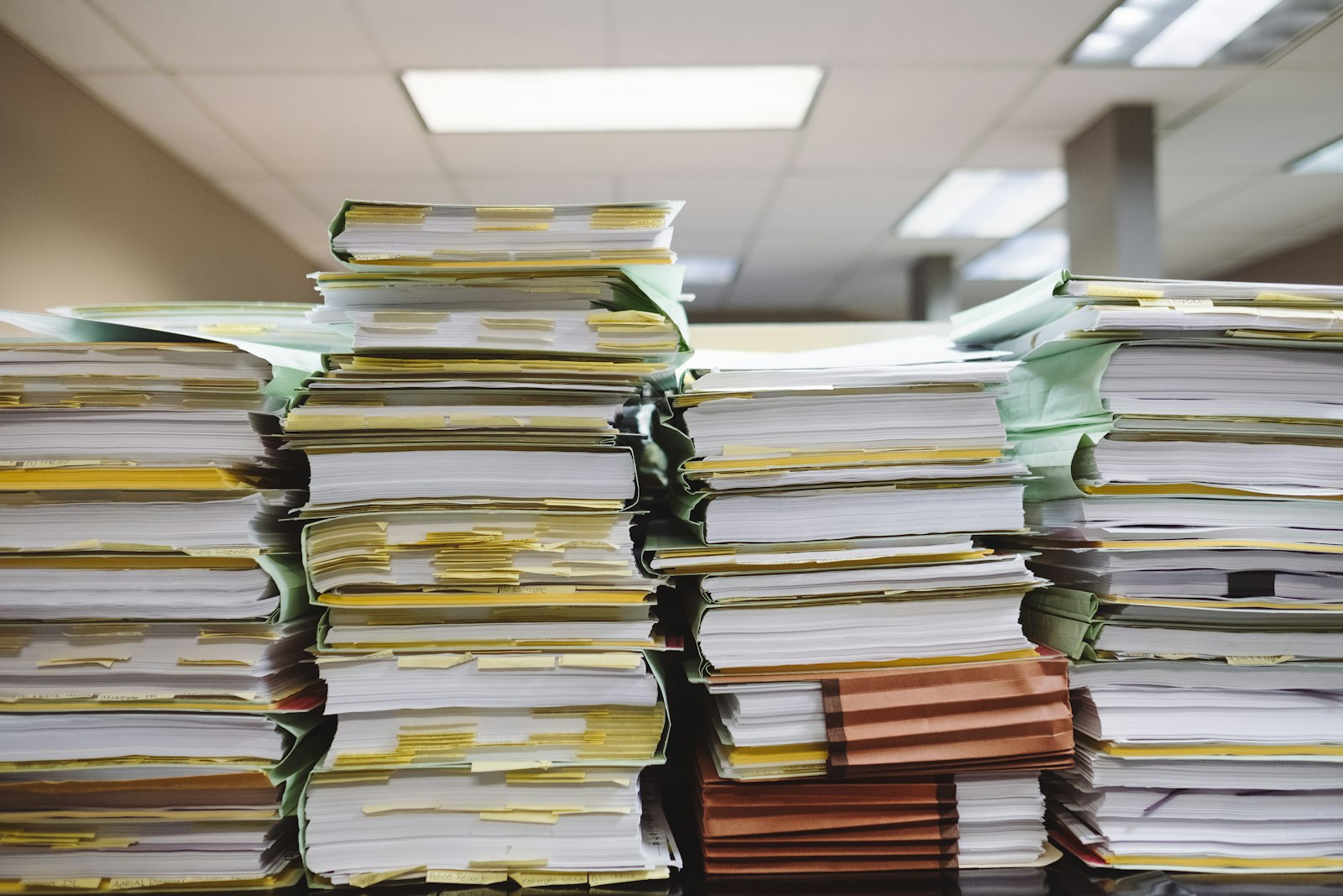 Stacks of paper documents and file folders on shelves