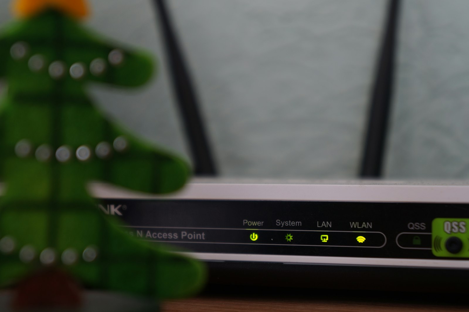 White and black modem router with four status lights lit